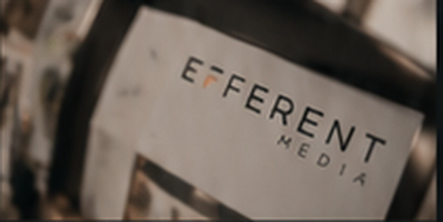 Efferent Media business card under a loupe